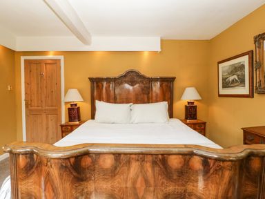 A bedroom with a wooden bed and two bedside tables with lamps at Valley House in Devizes
