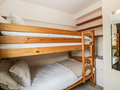 A bedroom with wooden bunk beds and shelves on the wall at Valley House in Devizes