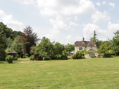 A house with trees sheds and a large grassy lawn at Valley House in Devizes