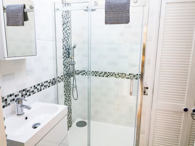 A bathroom with a shower enclosure sink and a towel hanging at Furneaux Hatch in Churchstow
