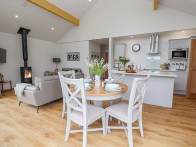 A kitchen and dining area with a round table set for four in an open plan living space at Pen Bryn in Cyffylliog near Ruthin