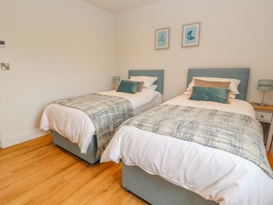 A bedroom with two single beds with blue headboards and bedside tables at Pen Bryn in Cyffylliog near Ruthin