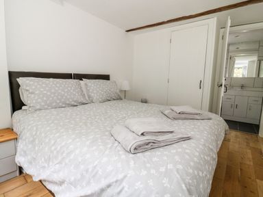 A bedroom with a double bed covered with patterned bedding and towels on the bed at Claire Cottage in Gateforth near Hambleton North Yorkshire