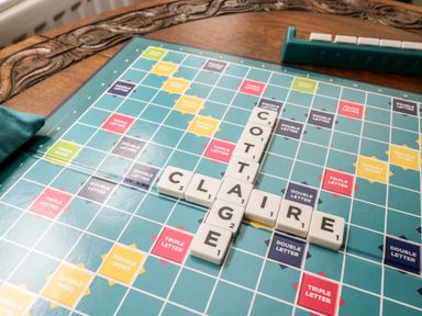 A Scrabble game board with the words COTTAGE and CLAIRE formed by letter tiles on a wooden table at Claire Cottage in Gateforth near Hambleton North Yorkshire