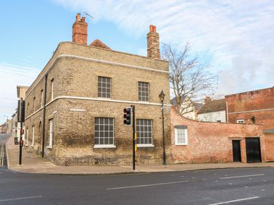 A brick building on a street corner with traffic lights and a sidewalk at Enterprise House in Bury St Edmunds