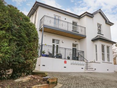 Outside view of a two story house with balconies and a paved driveway at Riviera Heights in Paignton