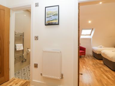 A hallway with a radiator a framed picture and views into a bathroom and a bedroom at Riviera Heights in Paignton