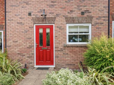 A red front door with a window next to it at Buck Place The Bay - Filey