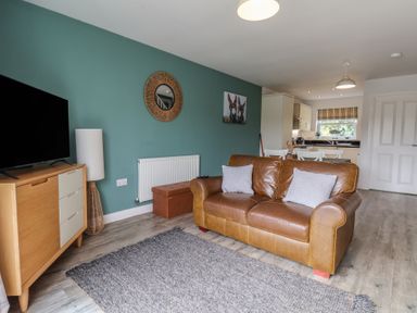 A living room with a sofa and television at Buck Place The Bay - Filey