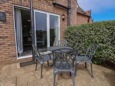 An outdoor seating area with a table and chairs at Buck Place The Bay - Filey