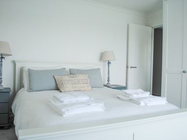 A bedroom with a bed set with towels and bedside lamps at 32 The Salcombe in Salcombe