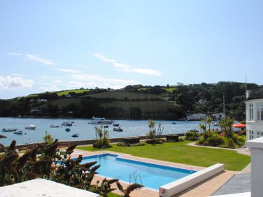 An outdoor area with a swimming pool and boats in the water at 32 The Salcombe Salcombe