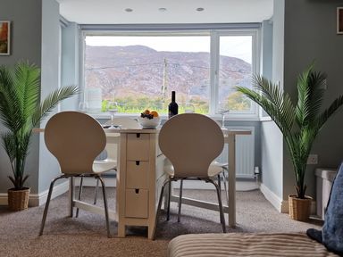 A dining room with a table and chairs overlooking mountains at Bryn in Bethesda