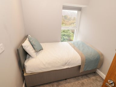 A small bedroom with a single bed next to a window showing a garden view at Annest in Bethesda