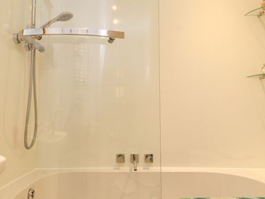 A bathroom with a bathtub and a showerhead above it at Bwthyn Gwyn Tyn Y Pant in Boduan near Nefyn
