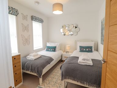 A bedroom with two single beds bedside table and drawers at Chandlers Retreat in Newport Pembrokeshire