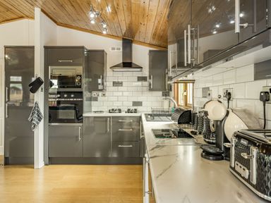 A kitchen with gray cabinets white subway tile backsplash and appliances at Lakeview Lodge in South Lakeland Leisure Village