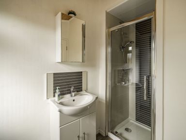 A bathroom with a sink cabinet and a shower with glass door at Lakeview Lodge in South Lakeland Leisure Village