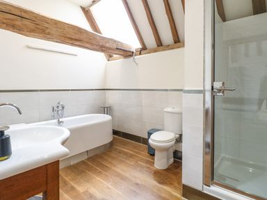 A bathroom with a bathtub toilet sink and shower at The Barn Tunstead near Hoveton and Wroxham