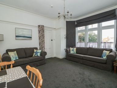 A living room with two brown sofas and sea themed cushions at Northgate Ground Floor Flat in Hunstanton