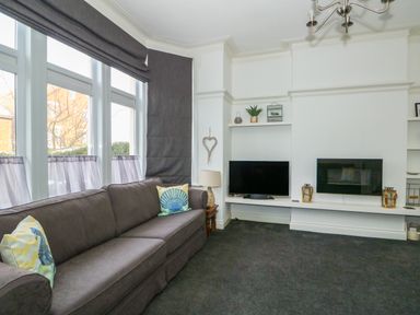 A living room with a sofa television and fireplace at Northgate Ground Floor Flat in Hunstanton