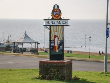 A sign with the name Hunstanton near a road with a pavilion a lamppost and the sea in the background at Northgate Ground Floor Flat in Hunstanton