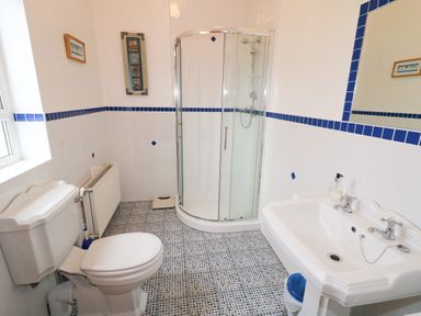 A bathroom with a toilet sink and corner shower at Ard an Phiobaire in An Luinnigh near Derrybeg County Donegal