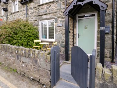 An outdoor area with a gate and bistro seating at Y Bwthyn in Llanbedr