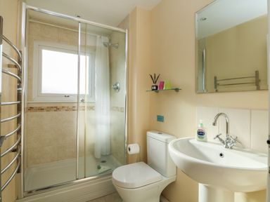 A bathroom with a shower cabin toilet sink mirror and towel rack at Kernyk in Perranuthnoe