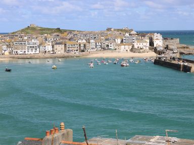 A coastal town with houses near a harbor filled with boats at The Beach Hut in St Ives
