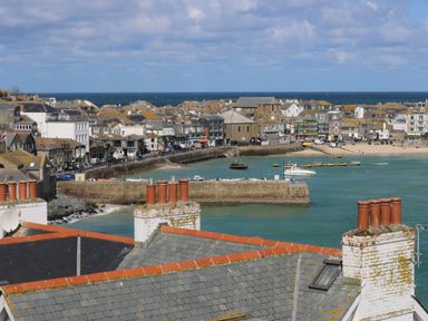 A coastal town with buildings and boats in the water at The Beach Hut in St Ives