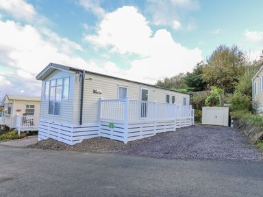 A mobile home with white railings and a small shed beside it at Ystwyth 26 in Borth