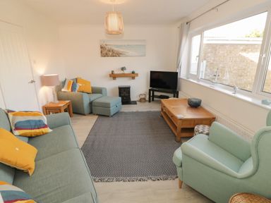 A living room with sofas armchair coffee table and television at Seaside retreat in Porthmadog
