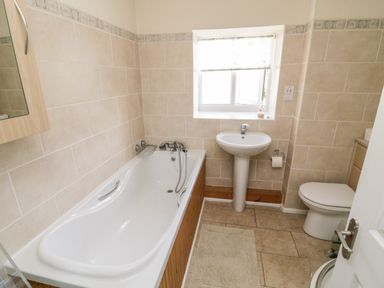 A bathroom with a bathtub sink toilet and window at Crooked Well in Timsbury Nr Bath