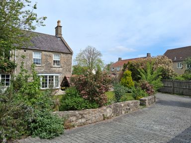 A garden with houses and pathway at Crooked Well in Timsbury, Nr Bath