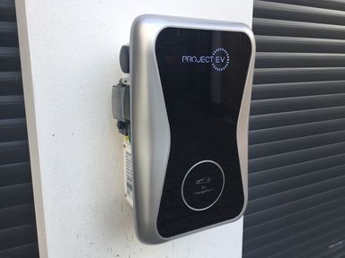 An electric vehicle charging station mounted on a white wall at The Old Coach House in Braunton