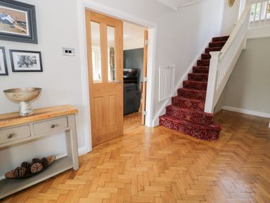 A hallway with a staircase and console table at Pengwern in Llanrwst