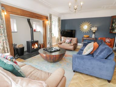 A living room with a coffee table and a wood stove at Pengwern in Llanrwst