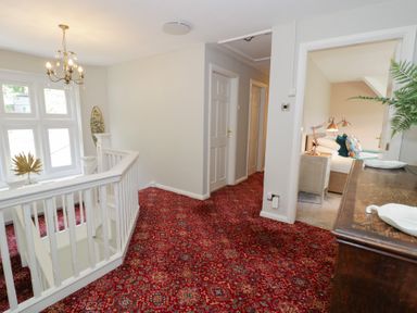 A hallway with a staircase and doorway to a room at Pengwern in Llanrwst