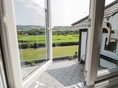 A view from a window overlooking a grassy area at Pengwern in Llanrwst