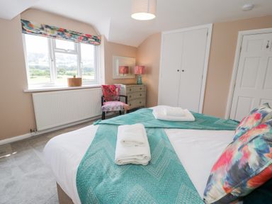 A bedroom with a bed and a chair at Pengwern in Llanrwst