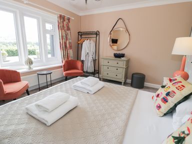 A bedroom with a bed and armchairs at Pengwern in Llanrwst