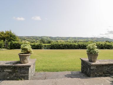 A garden view with planters and hills at Pengwern in Llanrwst