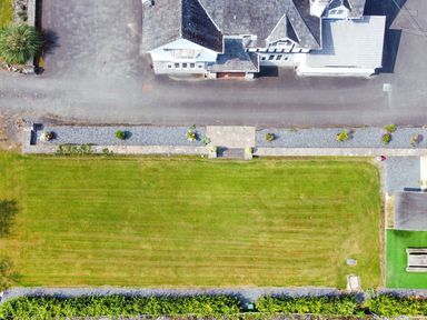 An outdoor view showing a lawn and house at Pengwern in Llanrwst