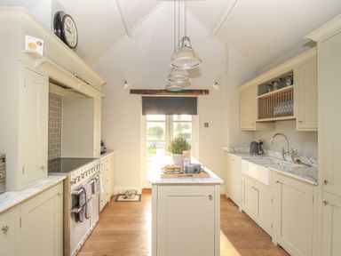 A kitchen with an island counter stove and sink at St Mary's Chapel in West Lulworth