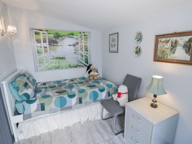 A bedroom with a single bed and a nightstand with a lamp at The Garden House in Upper Quinton near Lower Quinton