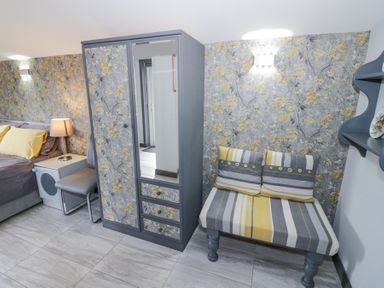 A bedroom with a bed lamp wardrobe chair and a striped cushioned bench at The Garden House in Upper Quinton near Lower Quinton