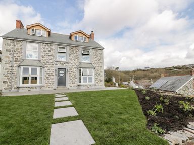 A stone house with a pathway through a grassy lawn and garden at Louvain in Cadgwith near Ruan Minor