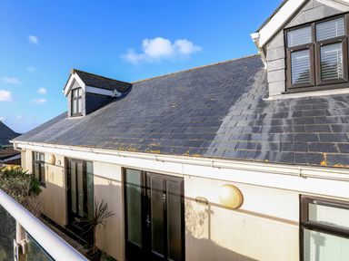 Exterior view of a building with a slate roof windows and doors under a clear blue sky at 2 The Bay in Bigbury
