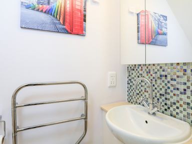 A bathroom sink with a faucet towel rack and mosaic tile backsplash at 2 The Bay in Bigbury